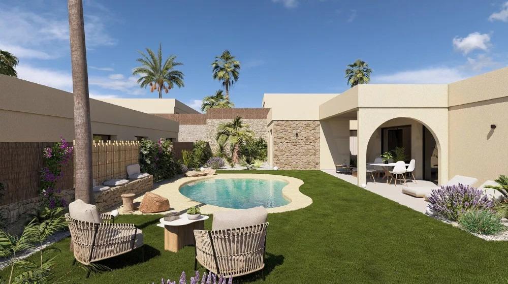 Backyard with a kidney-shaped pool, lounge chairs, and a covered patio in a beige desert-style home; palm trees rise above a green lawn.