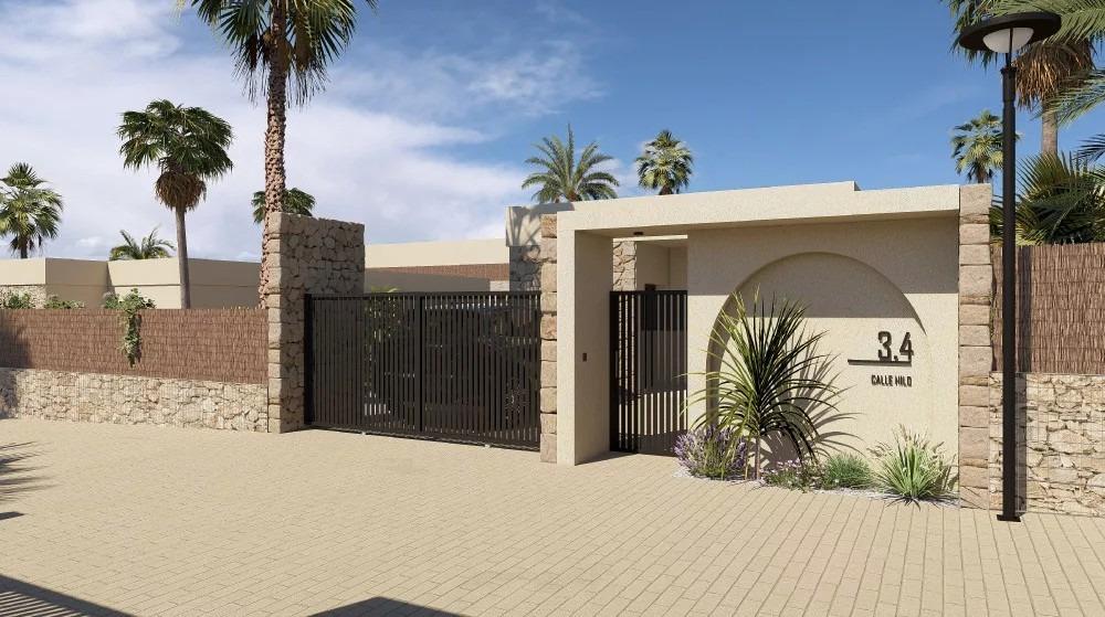Gated beige entrance to a modern property with stone walls, palm trees, and a circular wall displaying the number 34.